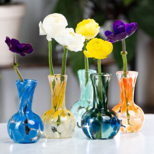 Image of 5 small glass vases with globed bases. Each vase holds a flower.